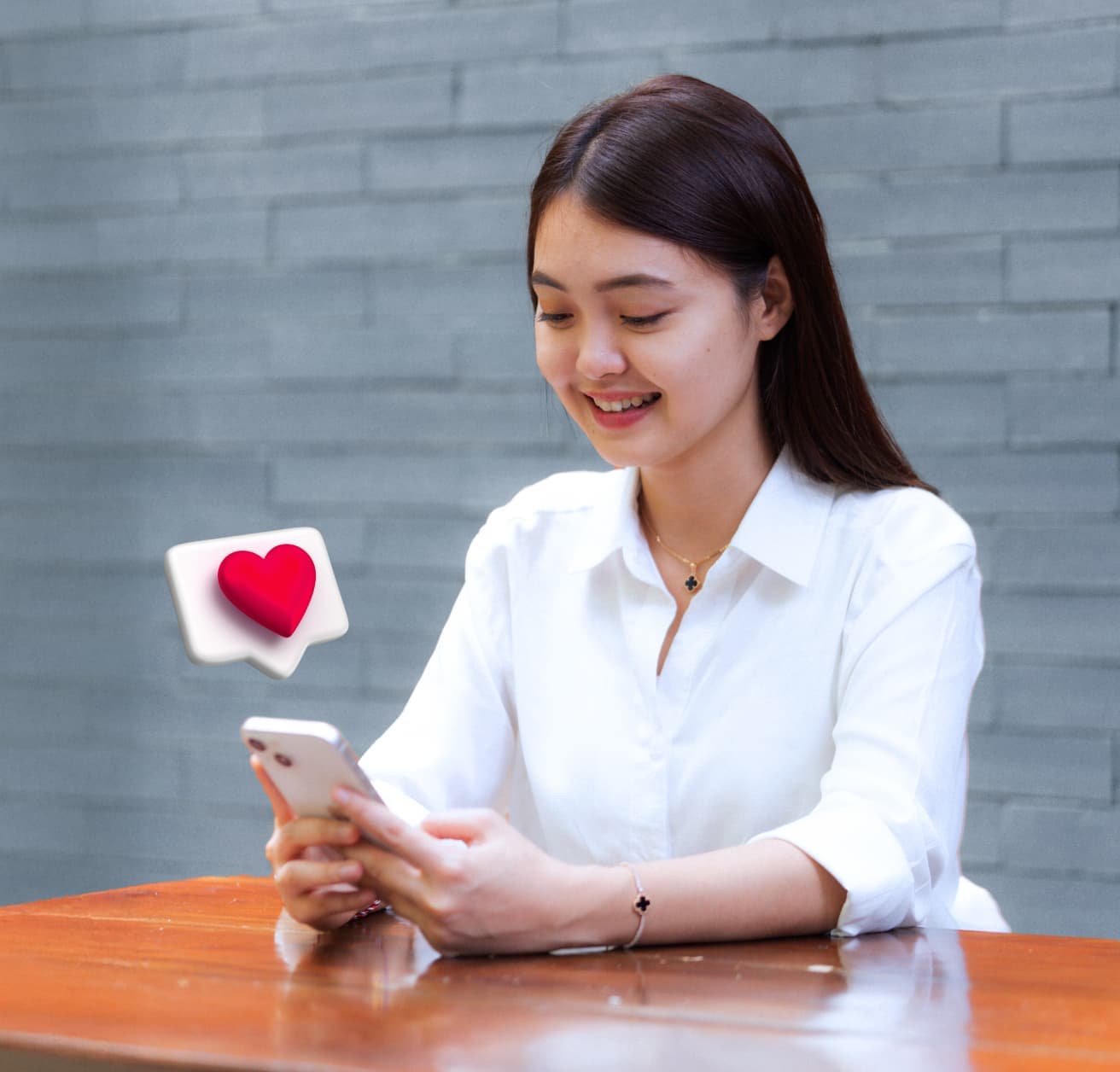 A woman wearing a white shirt while smiling and holding a smartphone in her hands.