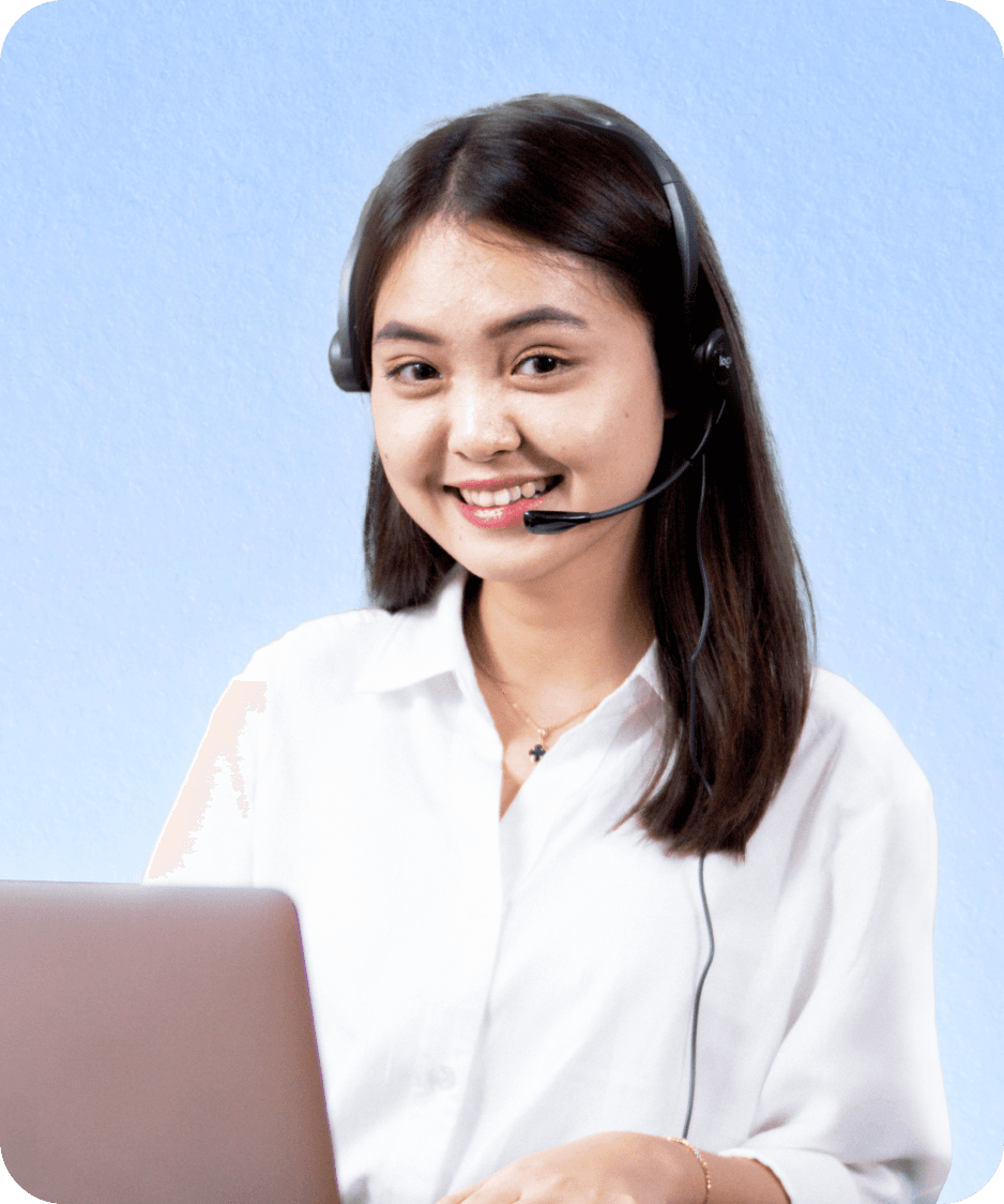 A woman, one of Topremit's Customer Support team, smiling and wearing a headset in front of a laptop.