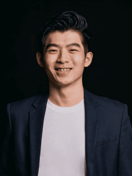 A portrait of Henry Wirawan, one of Topremit's co-founders, confidently smiles in a black suit layered over a white t-shirt.