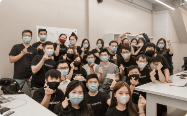 Topremit team wearing masks and Topremit t-shirts, posing toward the camera in 2020.