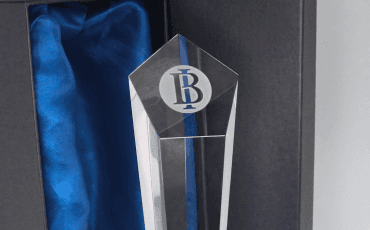 A 2022 award from Bank Indonesia, a pentagon-shaped crystal trophy with the BI logo on top, placed inside a blue satin-lined box.