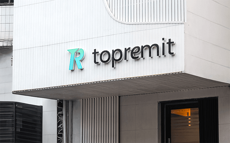 2023 年から現在までの Topremit オフィスで、建物正面に Topremit のロゴが掲げられた白い外観。